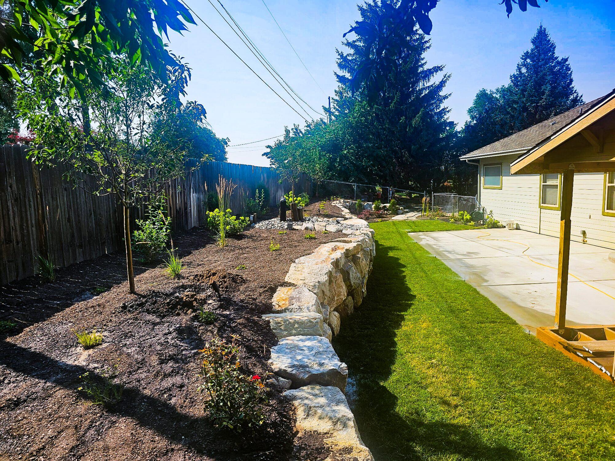 Boulder retaining wall with raised beds
